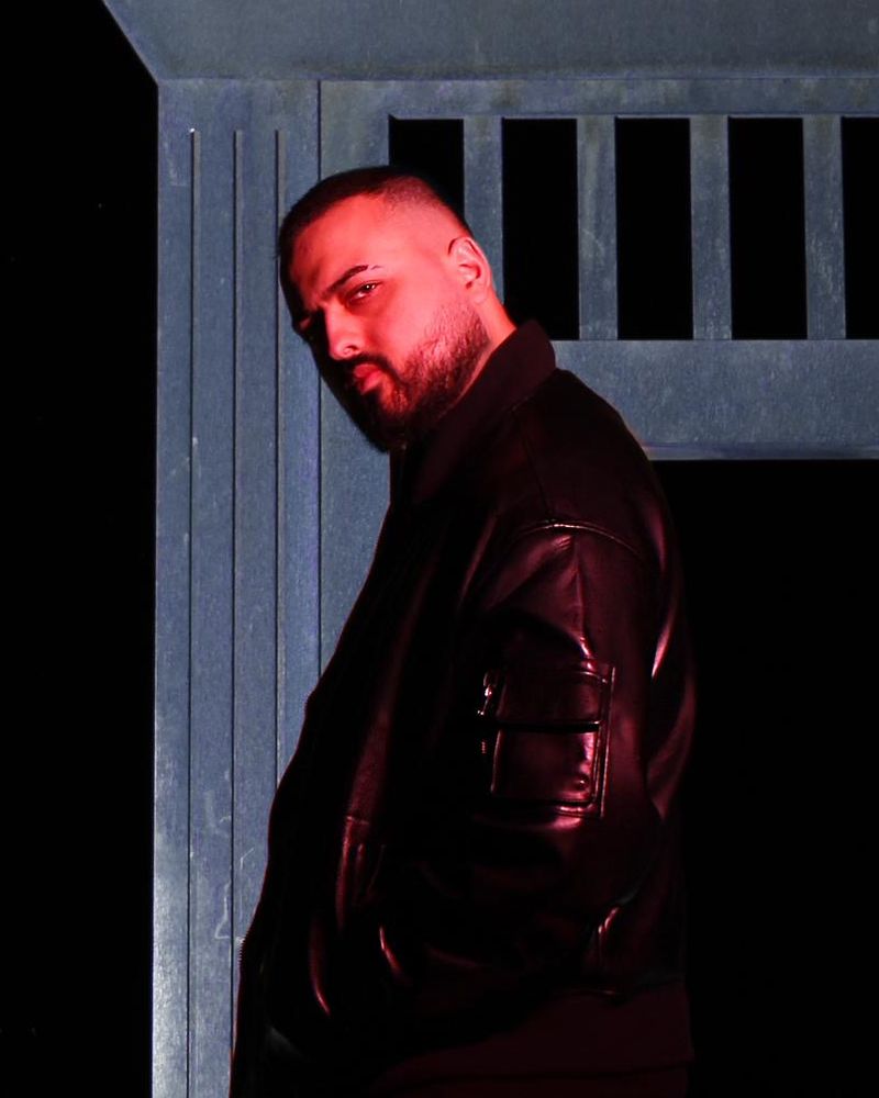 Jawedsway in a black leather jacket in front of a steel doorway